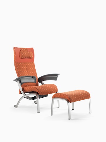 A patterned Nala Patient Chair and ottoman in shades of red and orange. Select to go to the Nala Patient Chair product page.